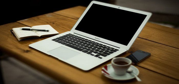 Escritorio con ordenador portátil, smartphone, café y bloc de notas Escritorio con ordenador portátil, smartphone, café y bloc de notas